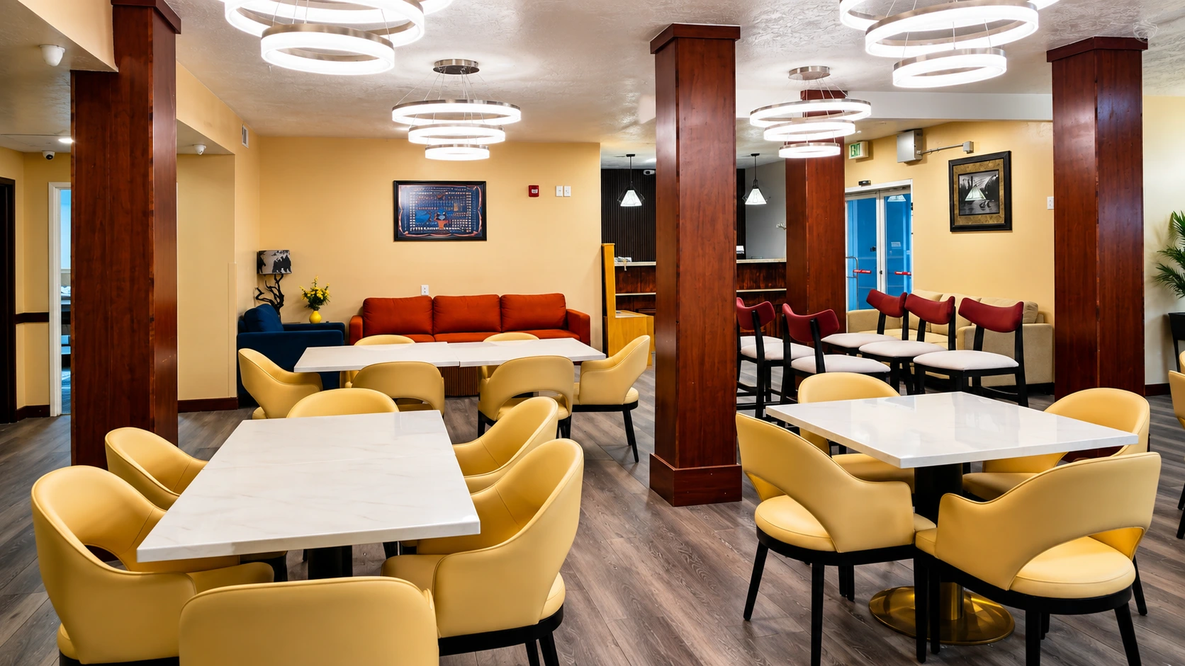 Breakfast dining room with marble-topped tables, ring pendant lights and lounge seating beyond — Best Western Vernal Inn, Vernal Utah
