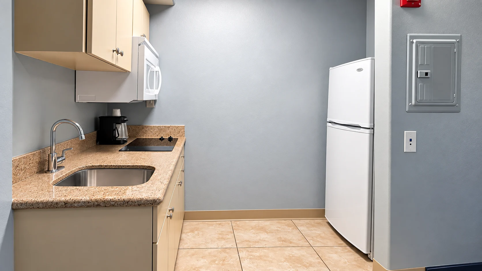 Kitchenette with two-burner cooktop, sink, microwave, coffee maker and full-height refrigerator — Best Western Vernal Inn, Vernal Utah