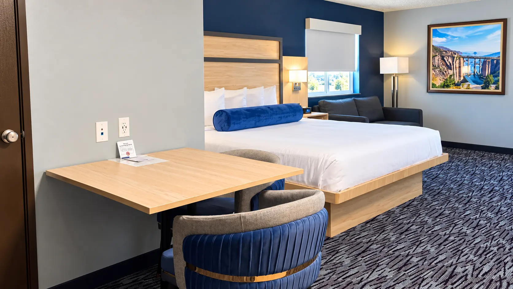 Table with two upholstered chairs, king bed and sofa seen from the door — Best Western Vernal Inn, Vernal Utah