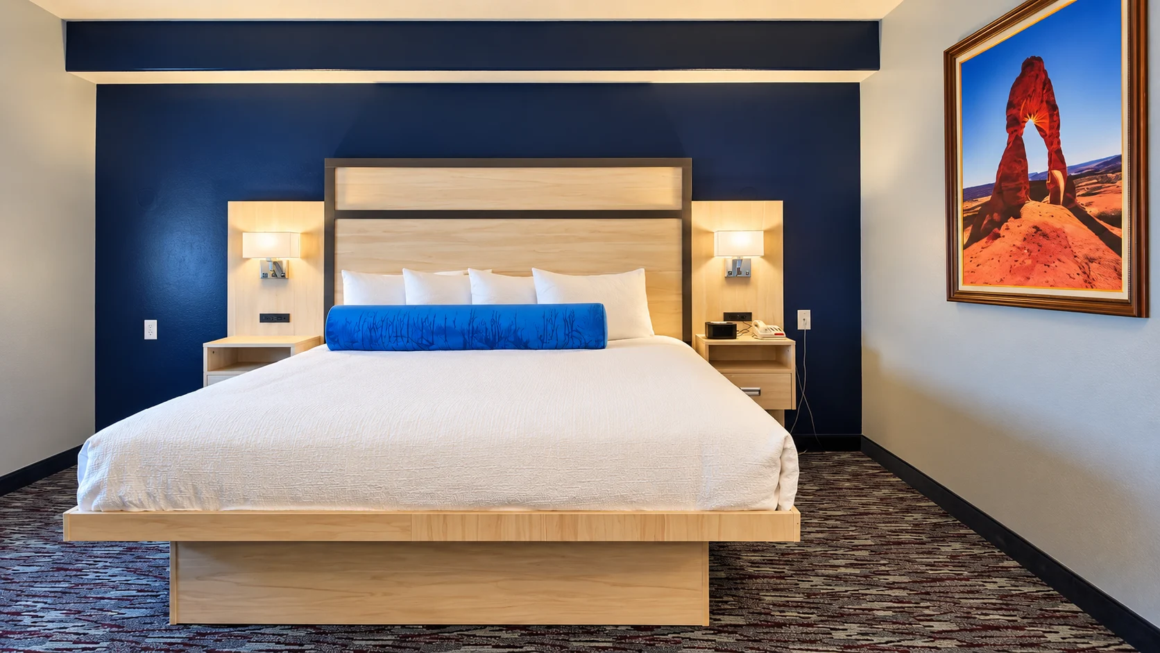 King bed with panelled headboard and wall reading lights in a Studio King room — Best Western Vernal Inn, Vernal Utah