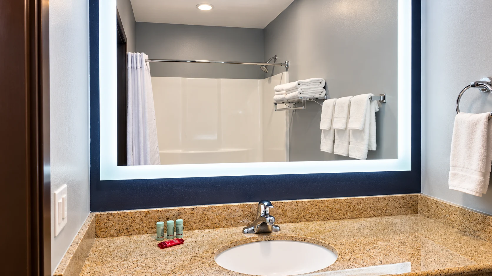 Bathroom vanity and backlit mirror reflecting the shower — Best Western Vernal Inn, Vernal Utah