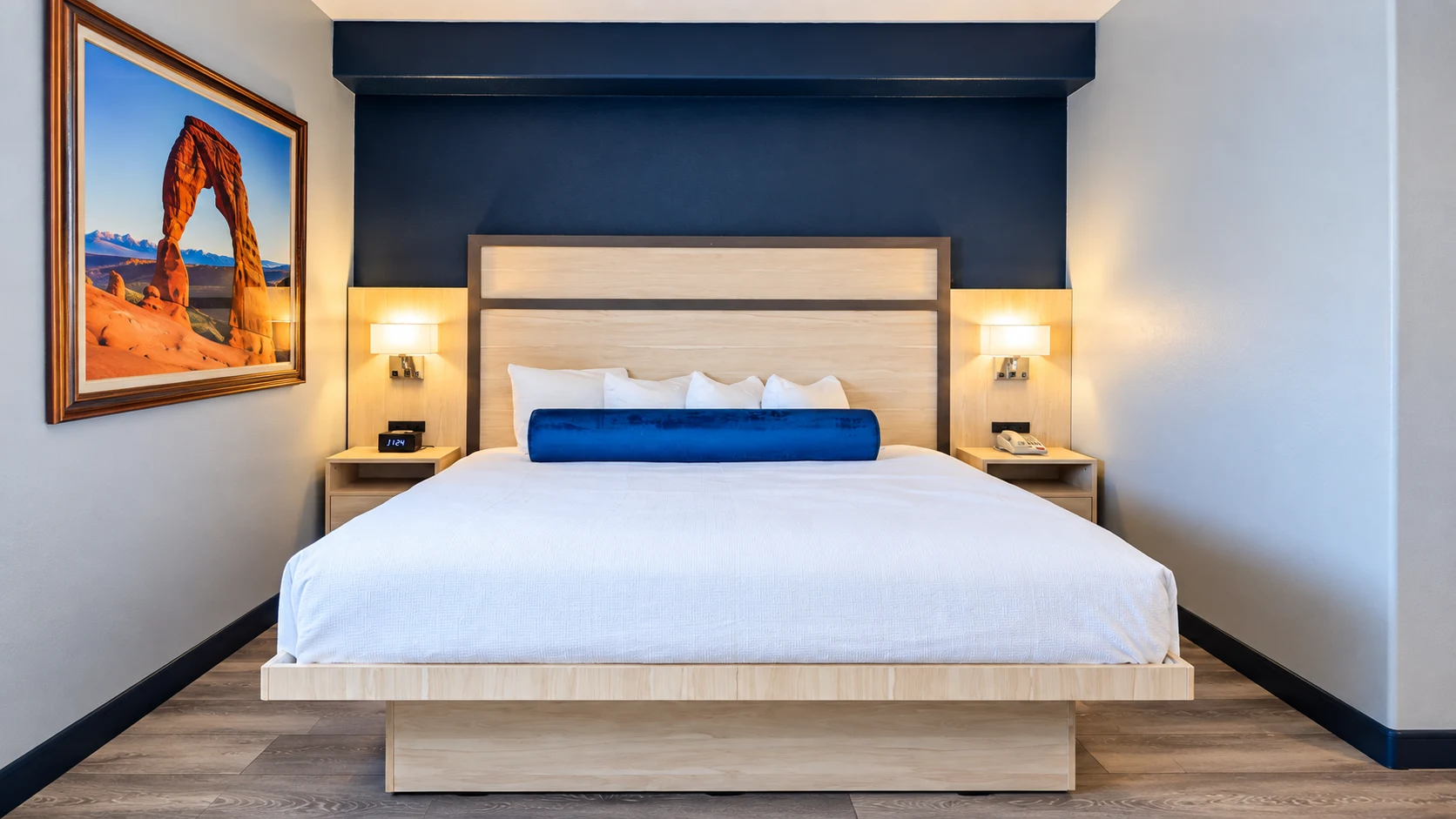 King bed with panelled headboard and wall reading lights on wood-style flooring — Best Western Vernal Inn, Vernal Utah